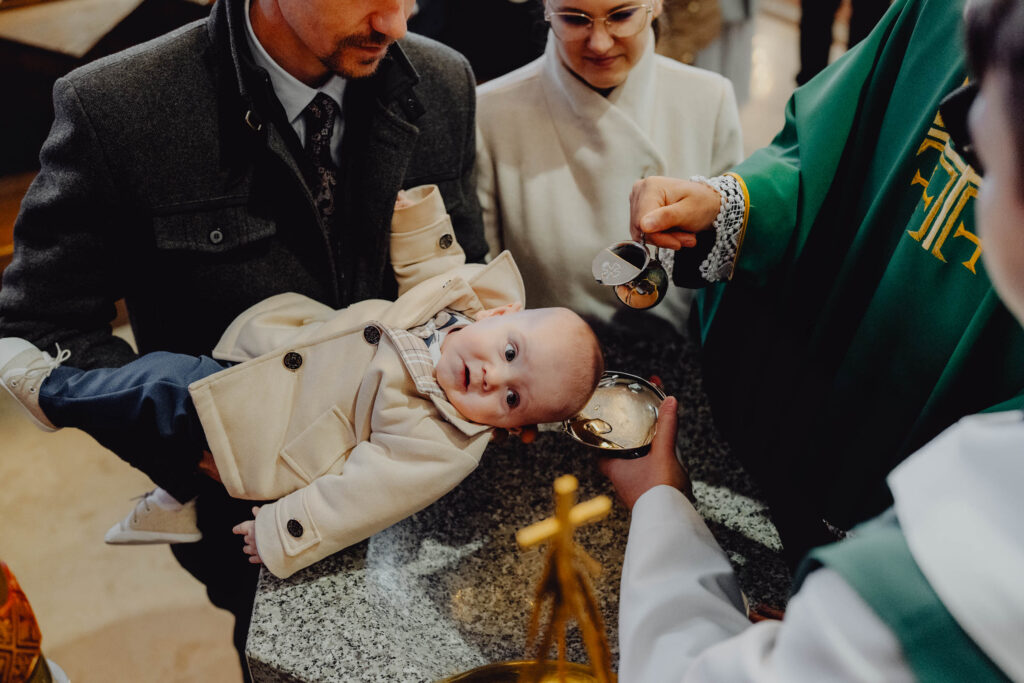 Ksiądz polewa głowę wodą święconą dla dziecka podczas chrztu w kościele matki kościoła w John stoku ksiądz polewa głowę wodą święconą dla dziecka podczas chrztu w kościele NMP matki kościoła w Białymstoku