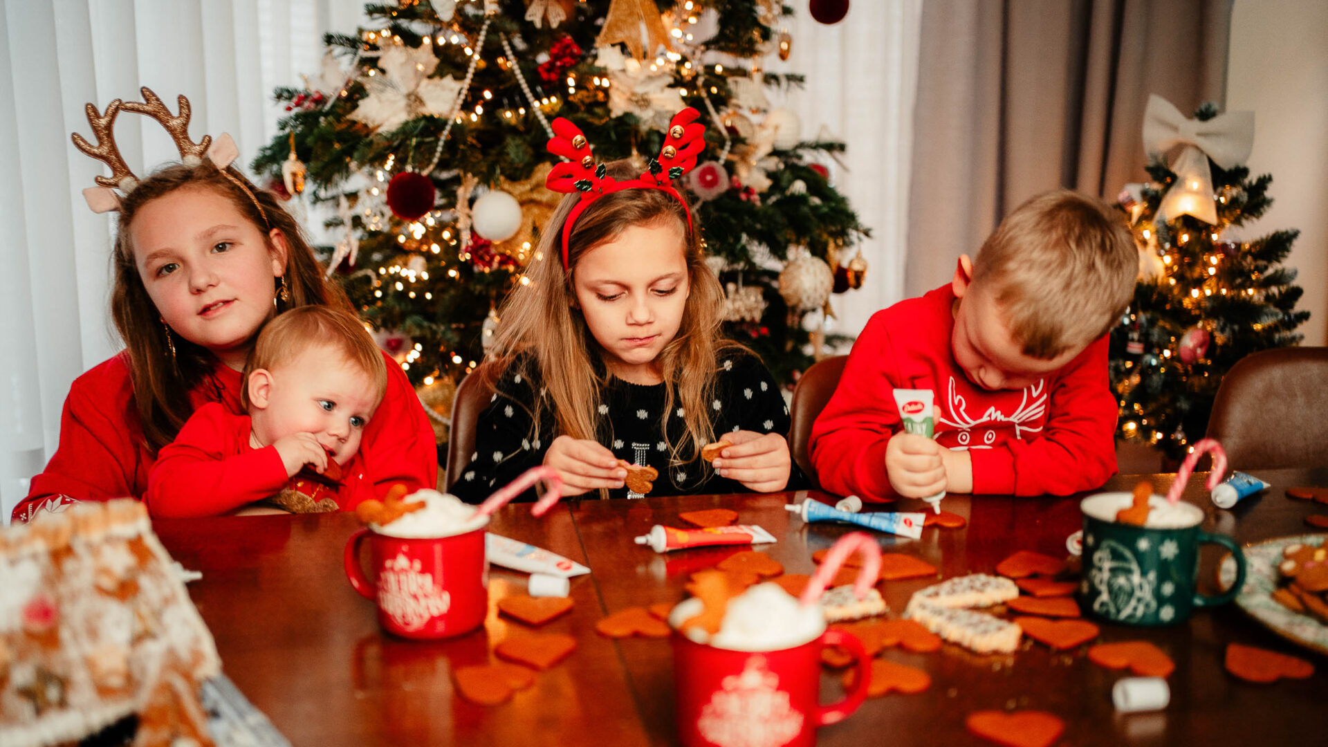 Wspólne pieczenie pierników przy stole podczas rodzinnej sesji świątecznej w domu.